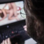 Man watching pornography on laptop at home