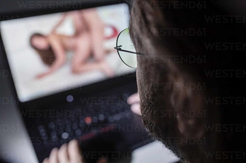 Man watching pornography on laptop at home